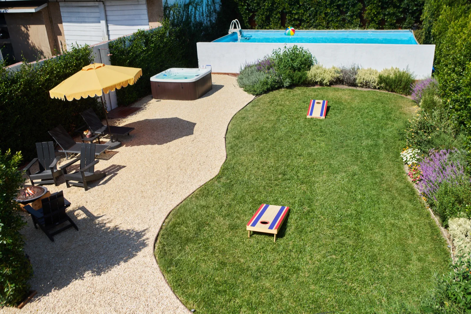 Aerial view of the backyard: pool, hot tub, umbrella and lawn